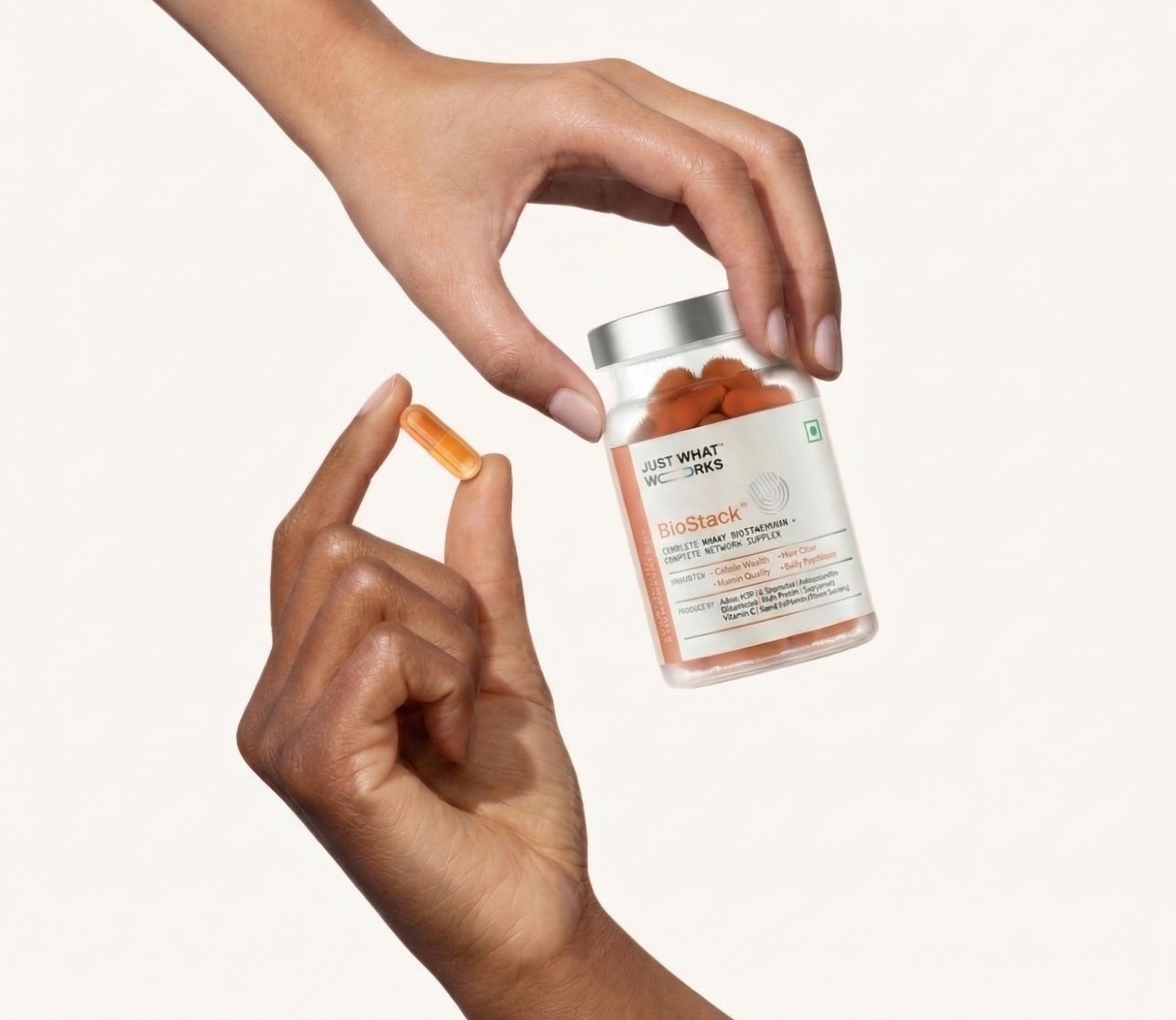 Person holding a bottle of supplements with a white background