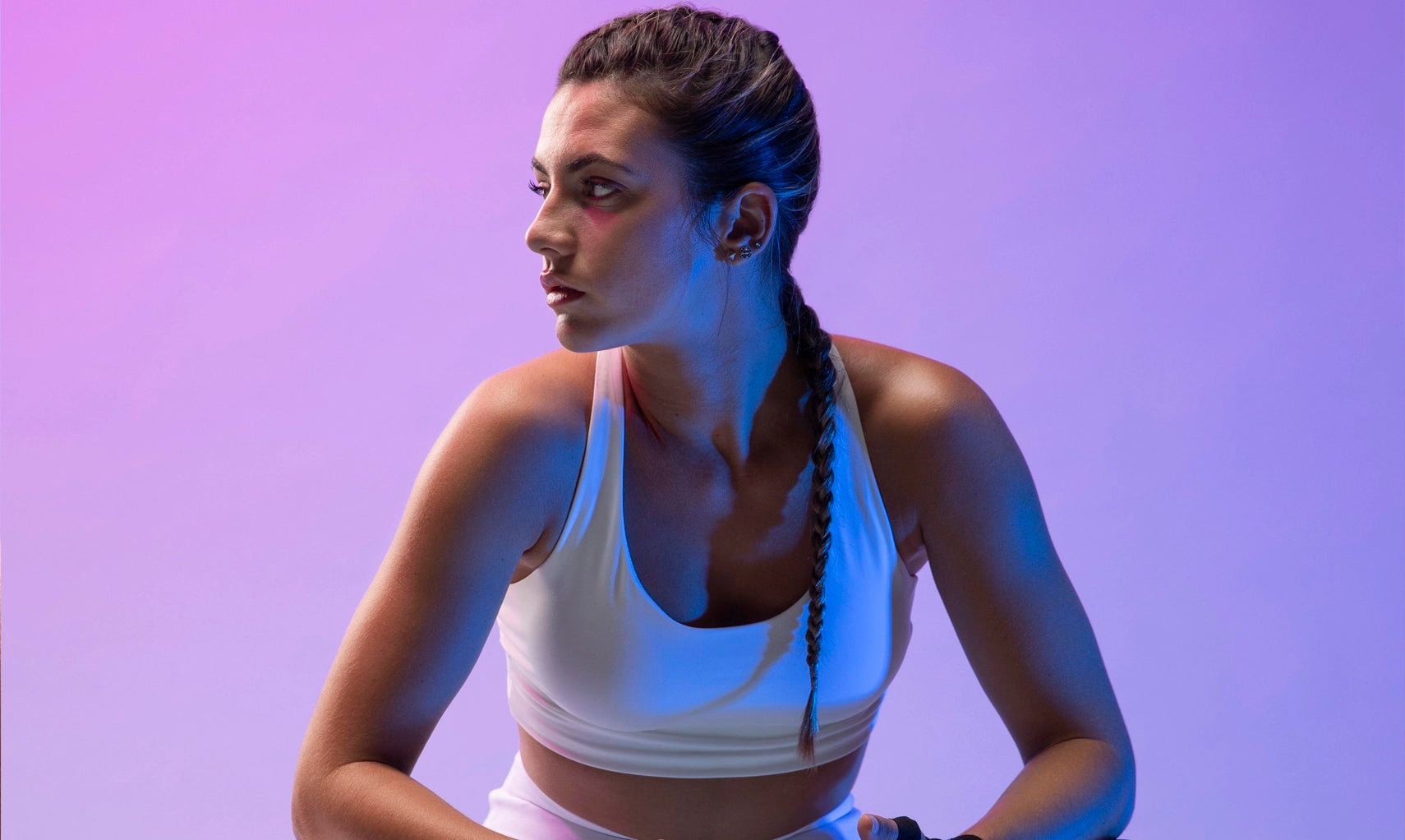Woman in athletic wear against a purple background