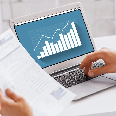 Person using a laptop with a graph on the screen, indicating data analysis or business tracking.