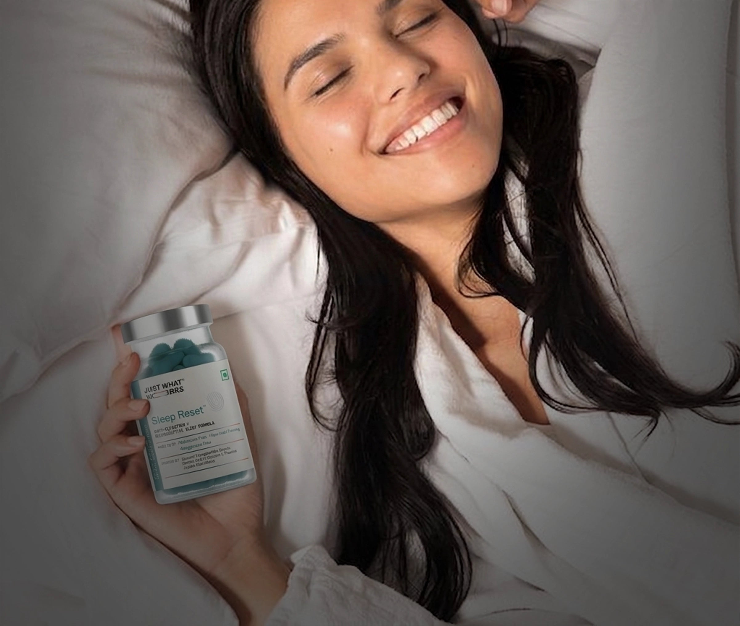Woman lying in bed holding a supplement container with a blurred background