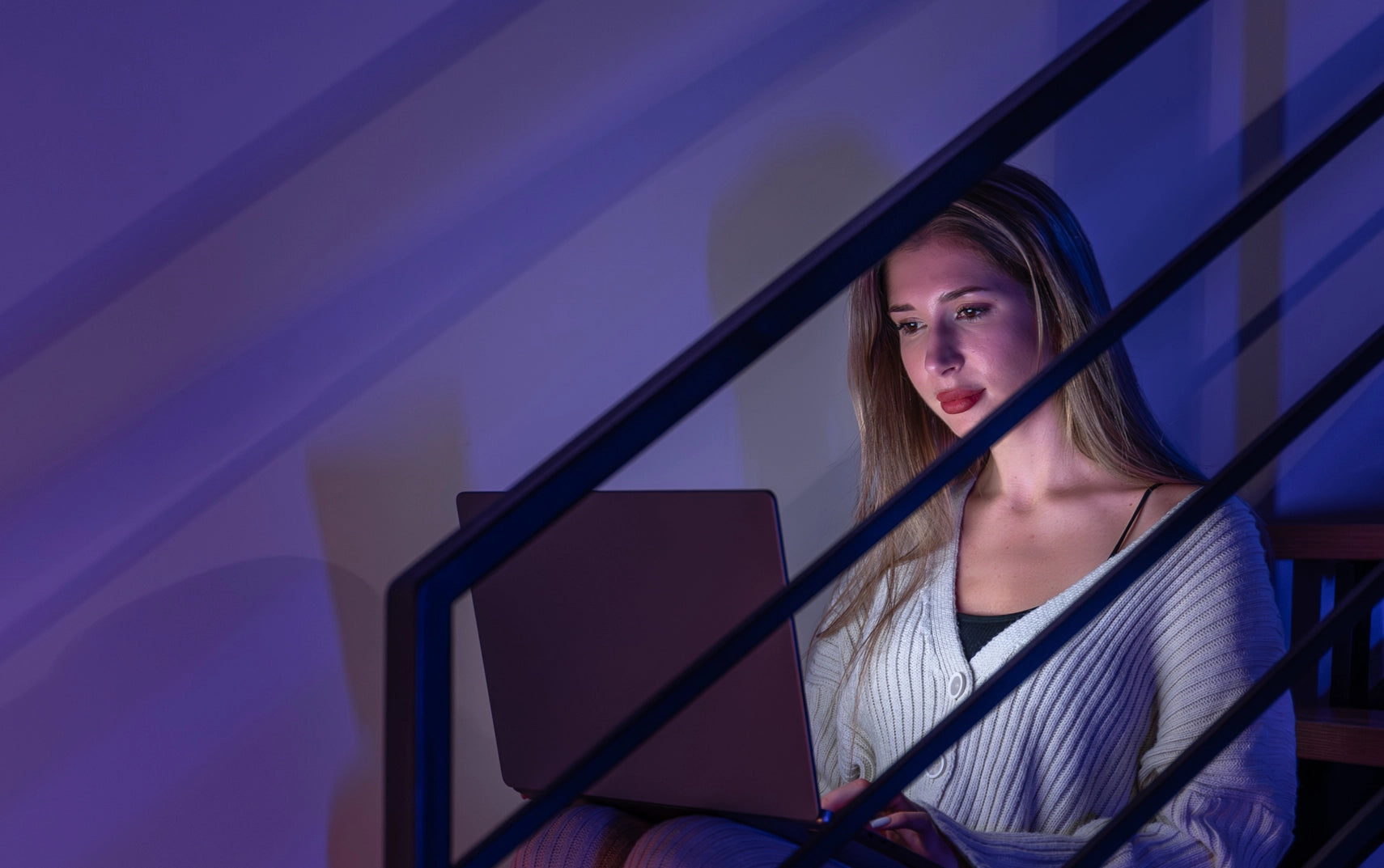 Woman using a laptop in a dimly lit room